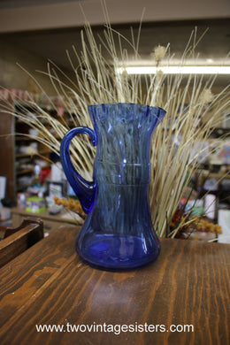 https://www.twovintagesisters.com/cdn/shop/products/CobaltBlue-Glass-Ruffelededge-pitcher-vintageglasspitcher_1_195x195@2x.jpg?v=1661806631